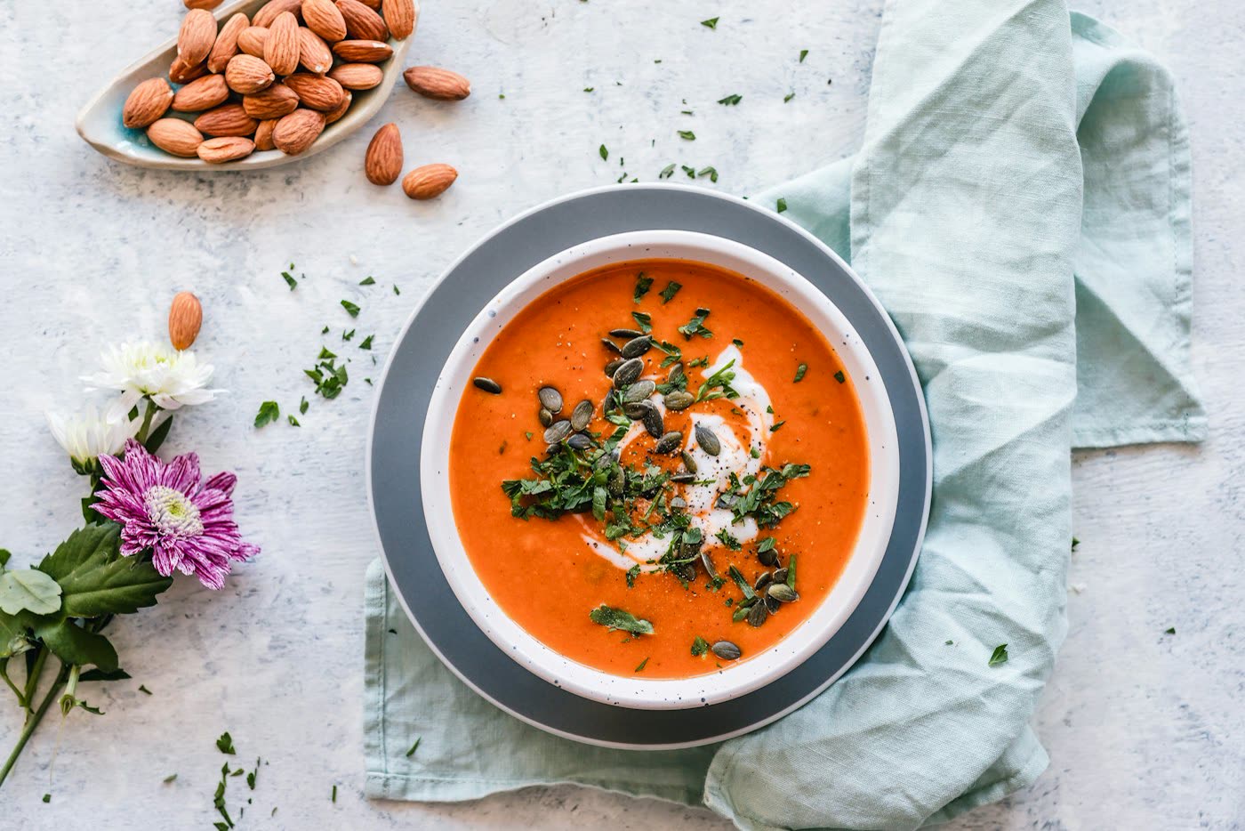 Bowl of vegetable soup with carrots, greens, and herbs
