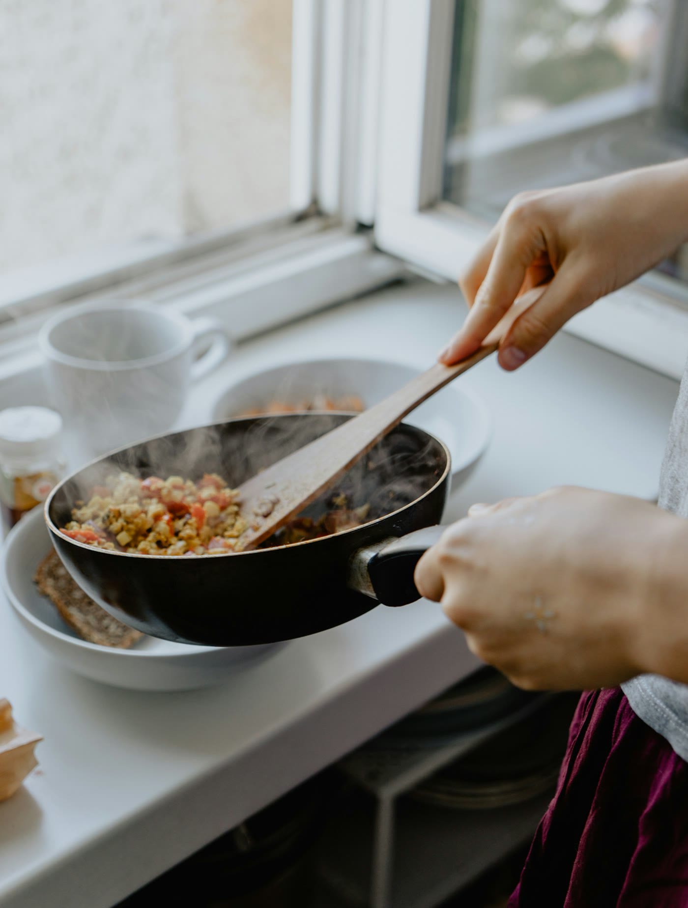 Friends cooking vegetables together in a bright kitchen